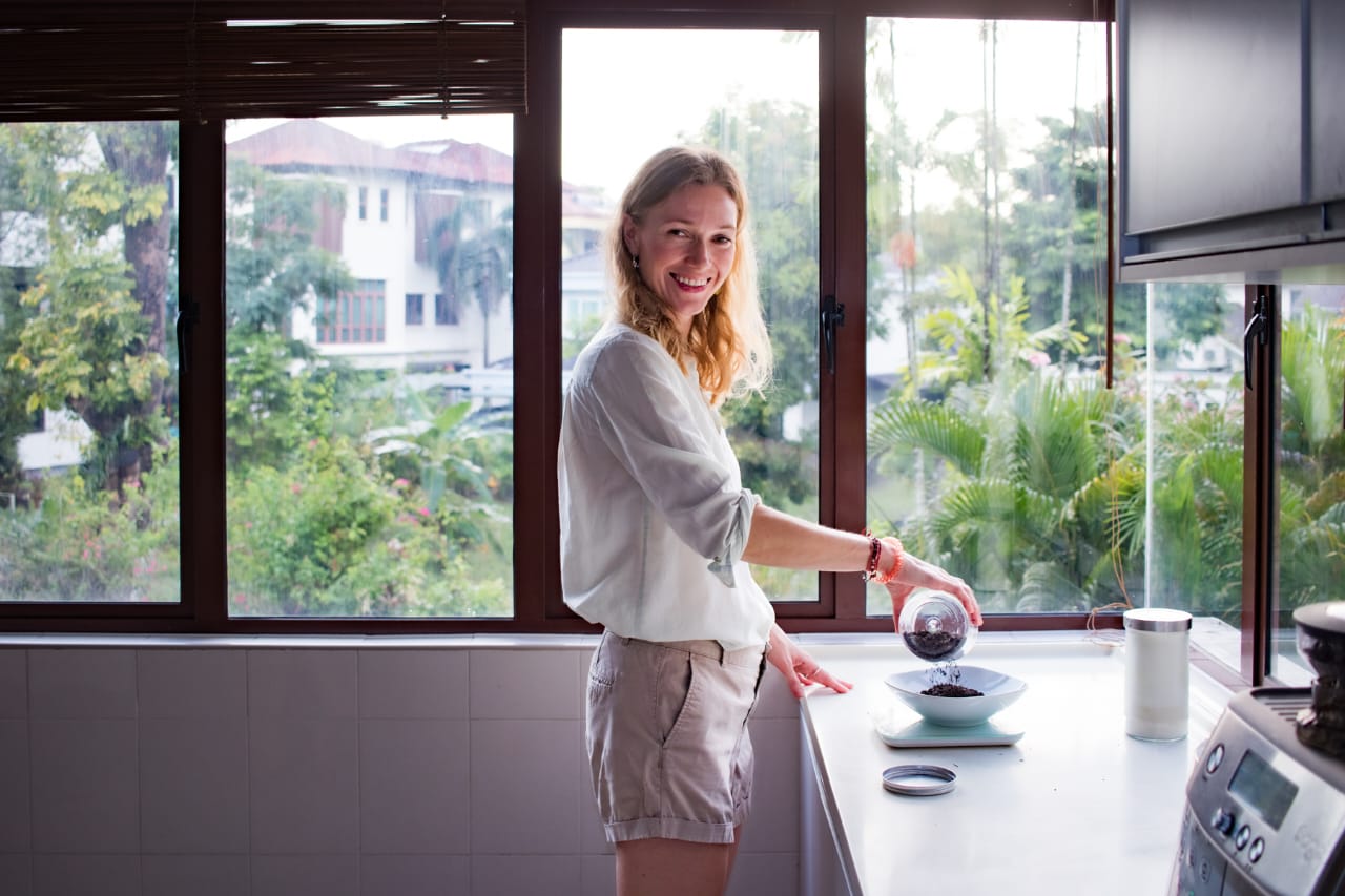 Founder weighing tea leaves in a sunlit kitchen