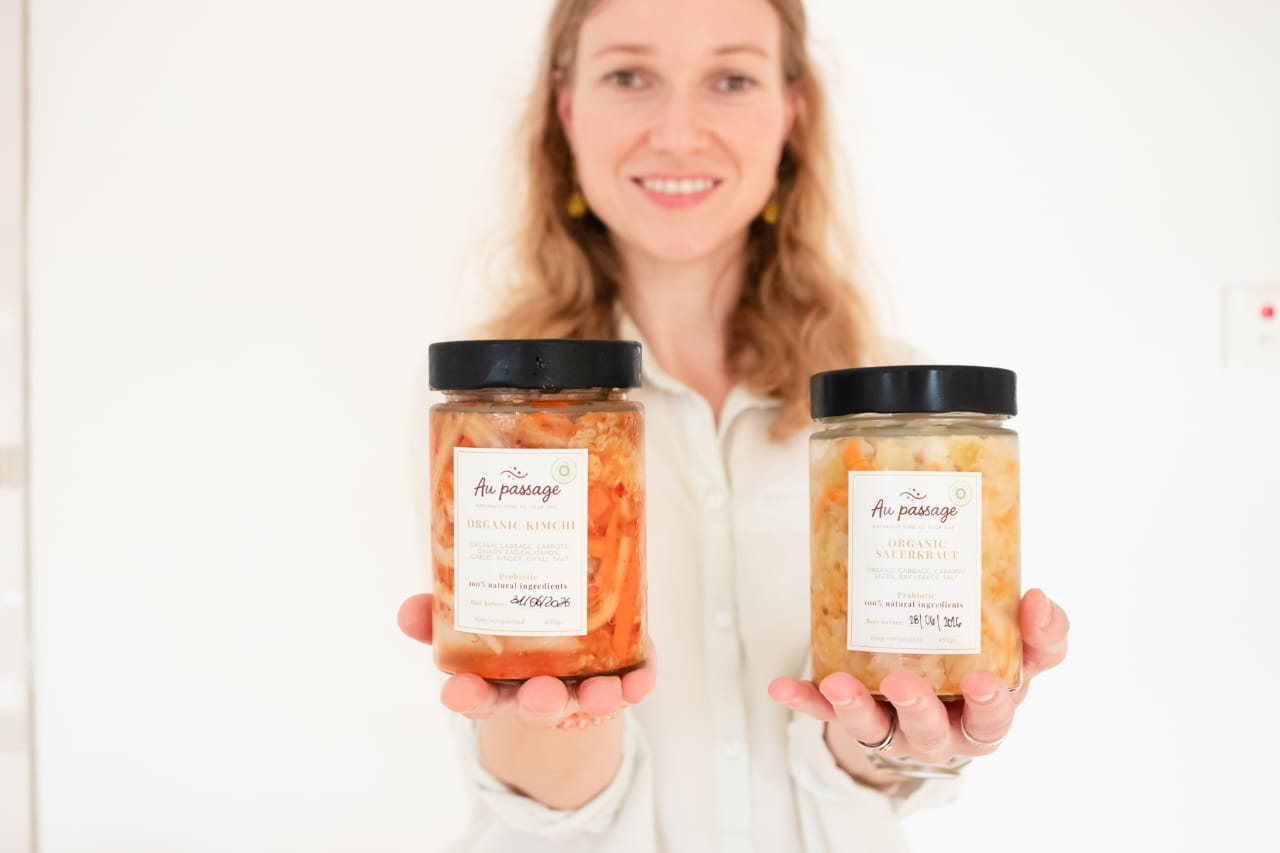 Founder holding jars of organic kimchi and sauerkraut